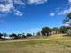 Landscaped golf course with mature trees and a partly cloudy sky at 14101 Vista Del Lago Blvd, Clermont, FL 34711