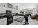Open kitchen with an island, black appliances, and view to the living room at 14101 Vista Del Lago Blvd, Clermont, FL 34711