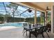 Screened-in pool area with a dining table, perfect for outdoor entertaining and relaxation by the beautiful pool at 14101 Vista Del Lago Blvd, Clermont, FL 34711