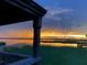 Picturesque sunset view from the porch, overlooking tranquil water and vibrant green marsh grass at 14101 Vista Del Lago Blvd, Clermont, FL 34711