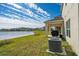 Backyard with covered patio, grill, and lake view at 1490 Woodmont Blvd, Kissimmee, FL 34746