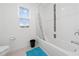 Clean bathroom with a bathtub, shower, and window at 1490 Woodmont Blvd, Kissimmee, FL 34746