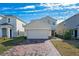 Two-story house with a two-car garage and a brick paver driveway at 1490 Woodmont Blvd, Kissimmee, FL 34746