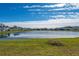 Community lake view with houses and lush grass at 1490 Woodmont Blvd, Kissimmee, FL 34746