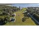 Aerial view of a serene park featuring picnic pavilions, playground equipment, and a vast open green space near the lake at 1595 Stone Trl, Deltona, FL 32725