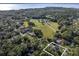 Expansive aerial view of property showing location near lake, green space, and lush trees at 1595 Stone Trl, Deltona, FL 32725