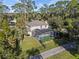 Aerial view of a beautiful home with a screened-in pool enclosure and a lush green lawn surrounded by mature trees at 1595 Stone Trl, Deltona, FL 32725