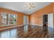 Bright bedroom boasts rich wood floors, ceiling fan, and a large window offering picturesque views at 1595 Stone Trl, Deltona, FL 32725
