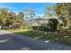 Exterior view of a beautifully landscaped home with screened-in pool enclosure and a well-maintained lawn at 1595 Stone Trl, Deltona, FL 32725