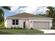 One-story home with a two-car garage and landscaped lawn at 1682 Blue Lagoon Cir, Mascotte, FL 34753
