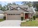Two-story house with a brown exterior, brick accents, and a two-car garage at 2705 Grantham Ct, Orlando, FL 32835