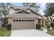 Two-story house with a brown exterior, brick accents, and a two-car garage at 2705 Grantham Ct, Orlando, FL 32835