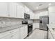 Modern kitchen featuring stainless steel appliances and granite countertops at 297 Jetty Way, Davenport, FL 33897