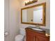 Powder room with dark vanity, large mirror, and toilet at 611 Buckhaven Loop, Ocoee, FL 34761