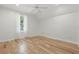 This bedroom boasts hardwood floors, a ceiling fan, and a window with natural light and white curtains at 6241 Blakeford Dr, Windermere, FL 34786