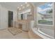 Spa-like bathroom with custom vanity, soaking tub, and a view of the outside at 6241 Blakeford Dr, Windermere, FL 34786
