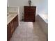 Bathroom with tile flooring, tiled tub, and wood vanity at 63 York Ct, Kissimmee, FL 34758