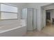 Bathroom with tiled tub and glass enclosed shower at 63 York Ct, Kissimmee, FL 34758