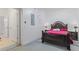 Bedroom with dark wood furniture and red bedding, next to a bathroom at 63 York Ct, Kissimmee, FL 34758