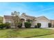 Tan house with a white garage door and well-manicured lawn at 63 York Ct, Kissimmee, FL 34758