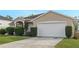 House exterior with a white garage door and landscaping at 63 York Ct, Kissimmee, FL 34758
