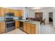Open concept kitchen and dining area with stainless steel appliances and wooden cabinets at 63 York Ct, Kissimmee, FL 34758