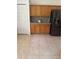 Cozy kitchen with wooden cabinets, stainless steel refrigerator and neutral tile floors at 63 York Ct, Kissimmee, FL 34758