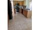 Well-lit kitchen with stainless steel appliances, wooden cabinets and neutral tile floors at 63 York Ct, Kissimmee, FL 34758