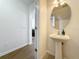 Small bathroom with pedestal sink and round mirror at 812 Park Grove Ct, Orlando, FL 32828