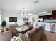 Open living room with modern furniture, hardwood floors, and a kitchen with stainless steel appliances at 812 Park Grove Ct, Orlando, FL 32828