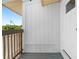 Small front porch with wood railing and gray flooring at 830 Garfish Ave, New Smyrna Beach, FL 32169