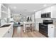Open kitchen with white cabinets, stainless steel appliances, and breakfast bar at 830 Garfish Ave, New Smyrna Beach, FL 32169