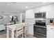 Kitchen features white cabinets, island with seating, and modern appliances at 830 Garfish Ave, New Smyrna Beach, FL 32169