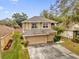 Two-story house with beige exterior, two-car garage, and surrounding homes at 8567 Baywood Vista Dr, Orlando, FL 32810