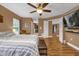 Spacious bedroom with wood floors and large TV at 8567 Baywood Vista Dr, Orlando, FL 32810