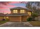 Two-story house with beige exterior, two-car garage, and landscaped yard at 8567 Baywood Vista Dr, Orlando, FL 32810