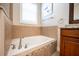Relaxing bathroom featuring a soaking tub, tile surround, and large window with blinds at 863 Strathmore Dr, Orlando, FL 32803