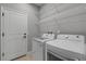 Bright laundry room with washer, dryer, and ample shelving at 906 Coral Reef Way, Daytona Beach, FL 32124