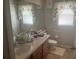 Bright bathroom with single sink vanity, toilet, and large mirror at 2776 Spicebush Loop, Apopka, FL 32712