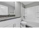 Bathroom with granite countertop, white cabinets, and shower/tub combo at 10 Cedar Tree Dr, Ocala, FL 34472