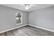 Simple bedroom with wood-look floors and ceiling fan at 10 Cedar Tree Dr, Ocala, FL 34472