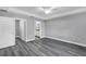 Bedroom with grey walls, wood-look floors, and access to bathroom at 10 Cedar Tree Dr, Ocala, FL 34472