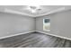 Spacious bedroom with grey walls, wood-look floors, and ceiling fan at 10 Cedar Tree Dr, Ocala, FL 34472