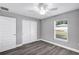 Bright bedroom with grey walls, wood-look floors, and ceiling fan at 10 Cedar Tree Dr, Ocala, FL 34472