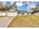 Newly built light green house featuring a white garage door and neat lawn at 10 Cedar Tree Dr, Ocala, FL 34472