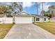 Newly constructed light green house with a white garage door and driveway at 10 Cedar Tree Dr, Ocala, FL 34472