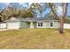 Newly built home showcasing a light green exterior, a white garage door, and a spacious lawn at 10 Cedar Tree Dr, Ocala, FL 34472