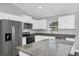 Modern kitchen featuring white cabinets, granite countertops, and stainless steel appliances at 10 Cedar Tree Dr, Ocala, FL 34472