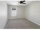 Spacious bedroom with grey carpet, ceiling fan and a window at 1162 Atlantic Ave, Fruitland Park, FL 34731