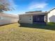 Exterior view of a single-story house with a screened patio and grassy backyard at 1162 Atlantic Ave, Fruitland Park, FL 34731